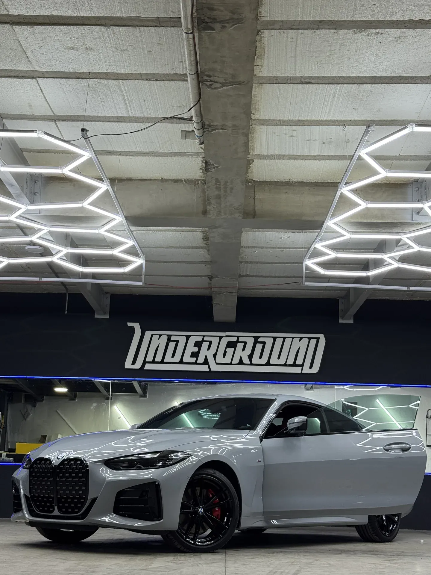 BMW M4 gris con recubrimiento cerámico frente al muro UNDERGROUND