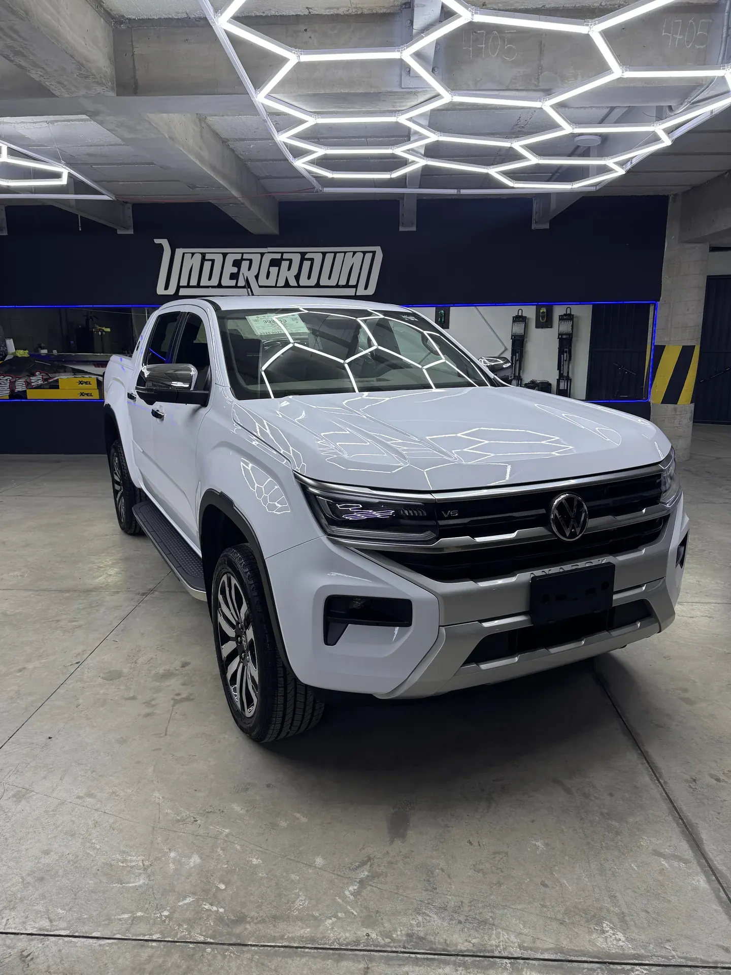 VW Amarok blanca después de un detailing completo, bajo el arreglo de luces LED hexagonales de UNDERGROUND